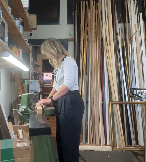 Working at the framing bench, surrounded by moulding stock